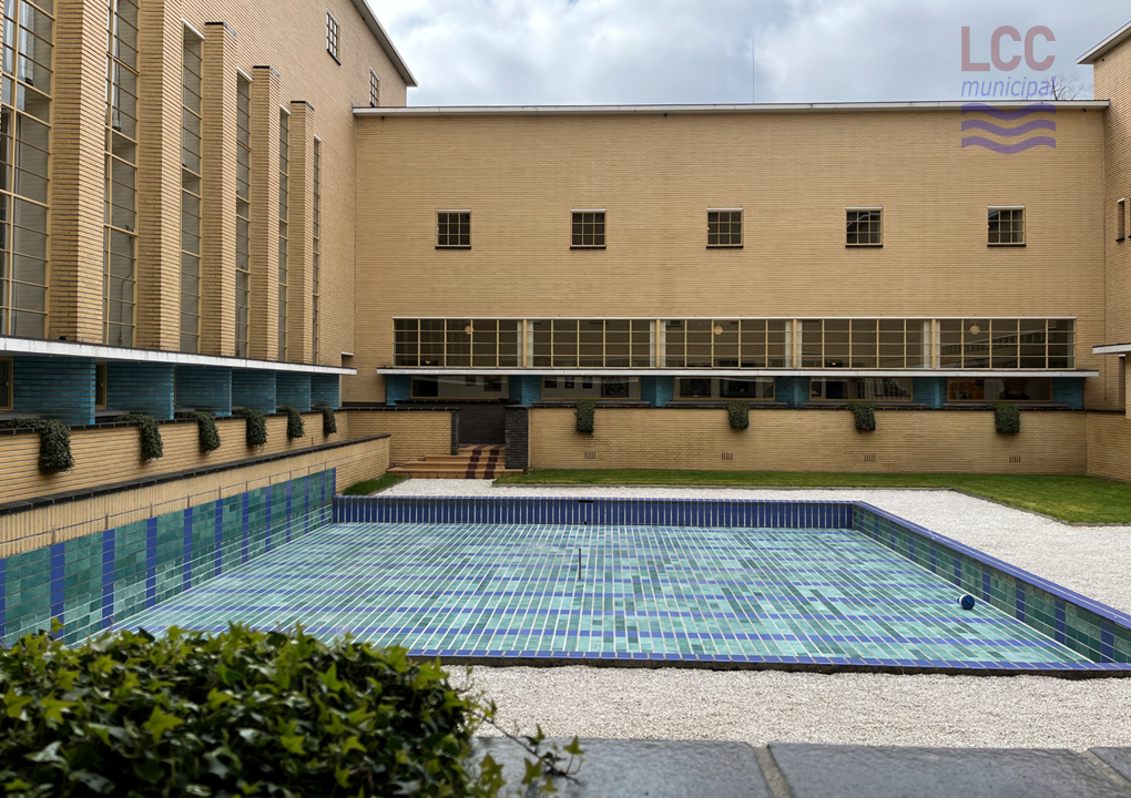 The courtyard is surrounded by the yellow brick walls of the Town Hall. At its centre is a square pool, which appears to be empty. The pool is lines with attractive blue/green tiles of various shades.