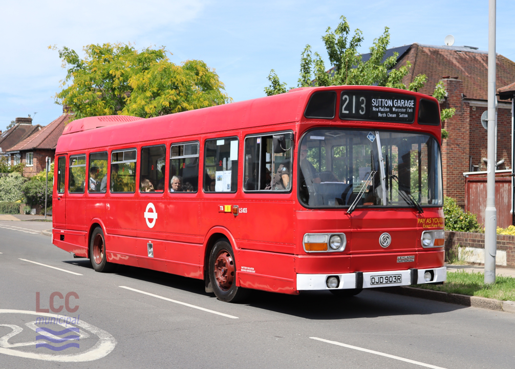 LS103 is a single deck Leyland National London Transport bus. It carries an all over red livery. It is seen on a suburban street with typical 1930s houses behind. It is on route 213 heading to Sutton Garage.