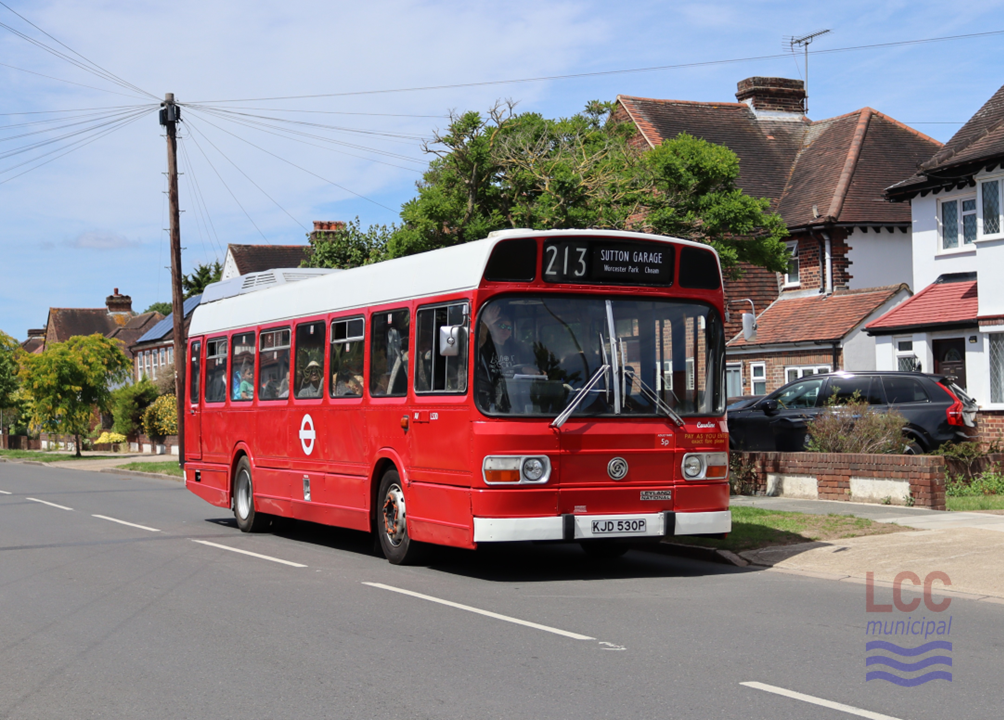 LS30 is a single deck Leyland National London Transport bus. It carries a red livery, but its roof is white. It is seen on a suburban street with typical 1930s houses behind. It is on route 213 heading to Sutton Garage.