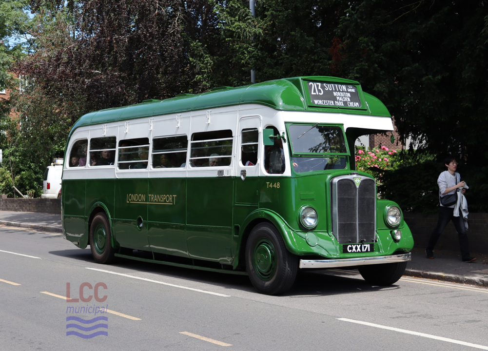 AEC Regal T448 is a single deck, green coach with a white band surrounding the saloon windows. It is seen here on a leafy green street, just by Kingston Hospital