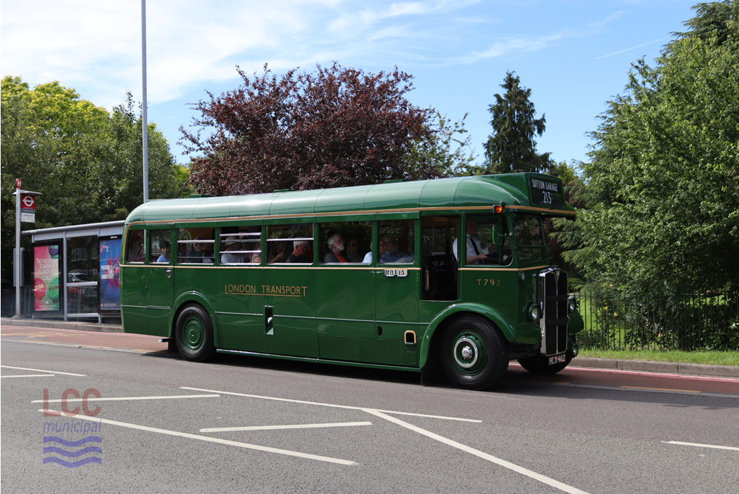 T792 is an AEC Regal is a single decker with a front engine and traditional half cab. It is painted in the green of London Transport's Country area. It has just left the bus stop at Quarry Park, the lawn and trees of which can be seen in the background.